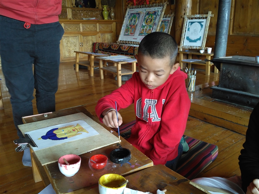 Chinese child, painting the head of Shakyamuni